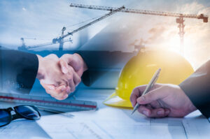 Affärsmän skakar hand efter överenskommelse för ny byggprojekt enligt kravspecifikationer.